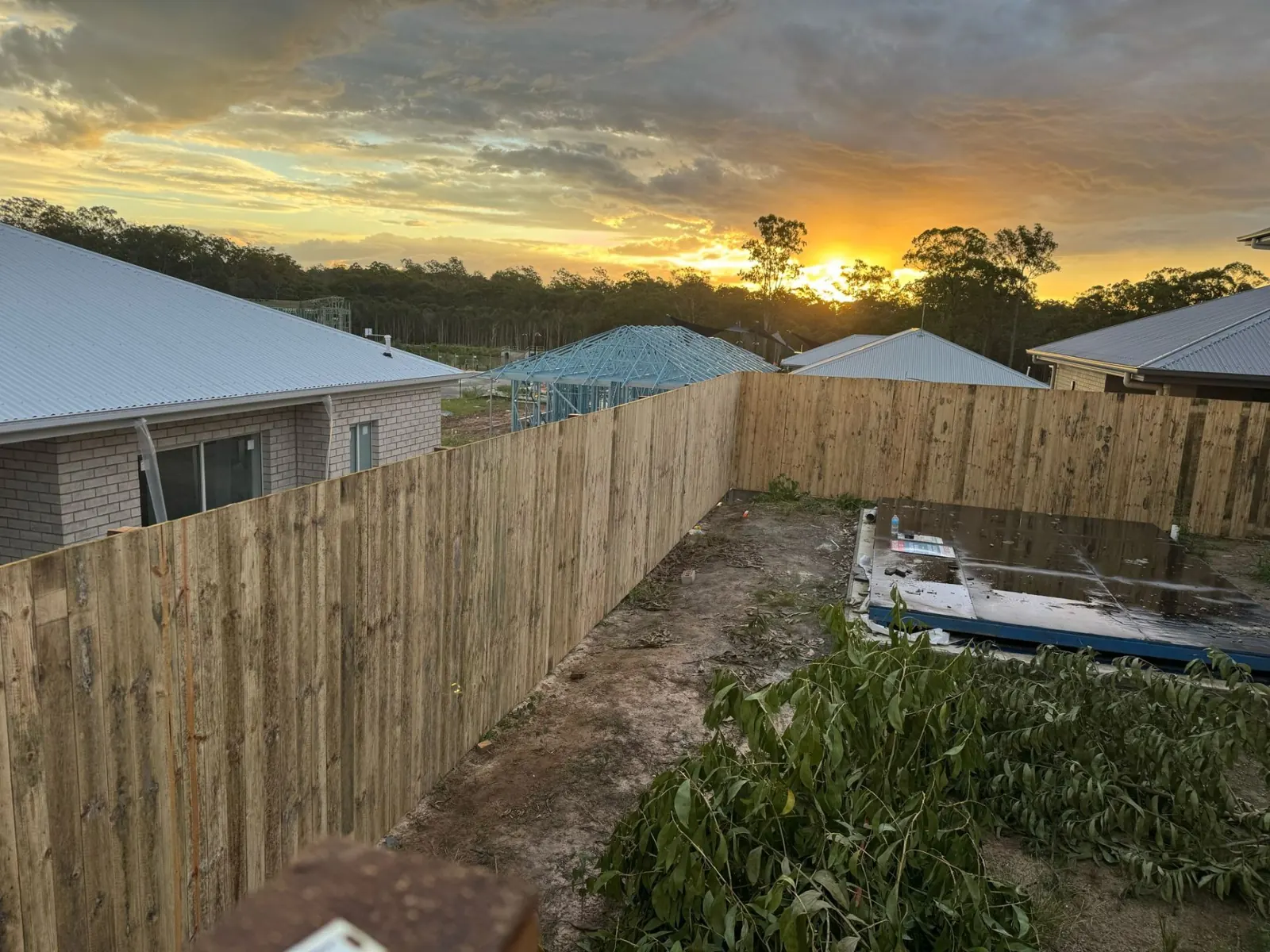 Full backyard timber paling fence overlooking new estate at sunset in Logan